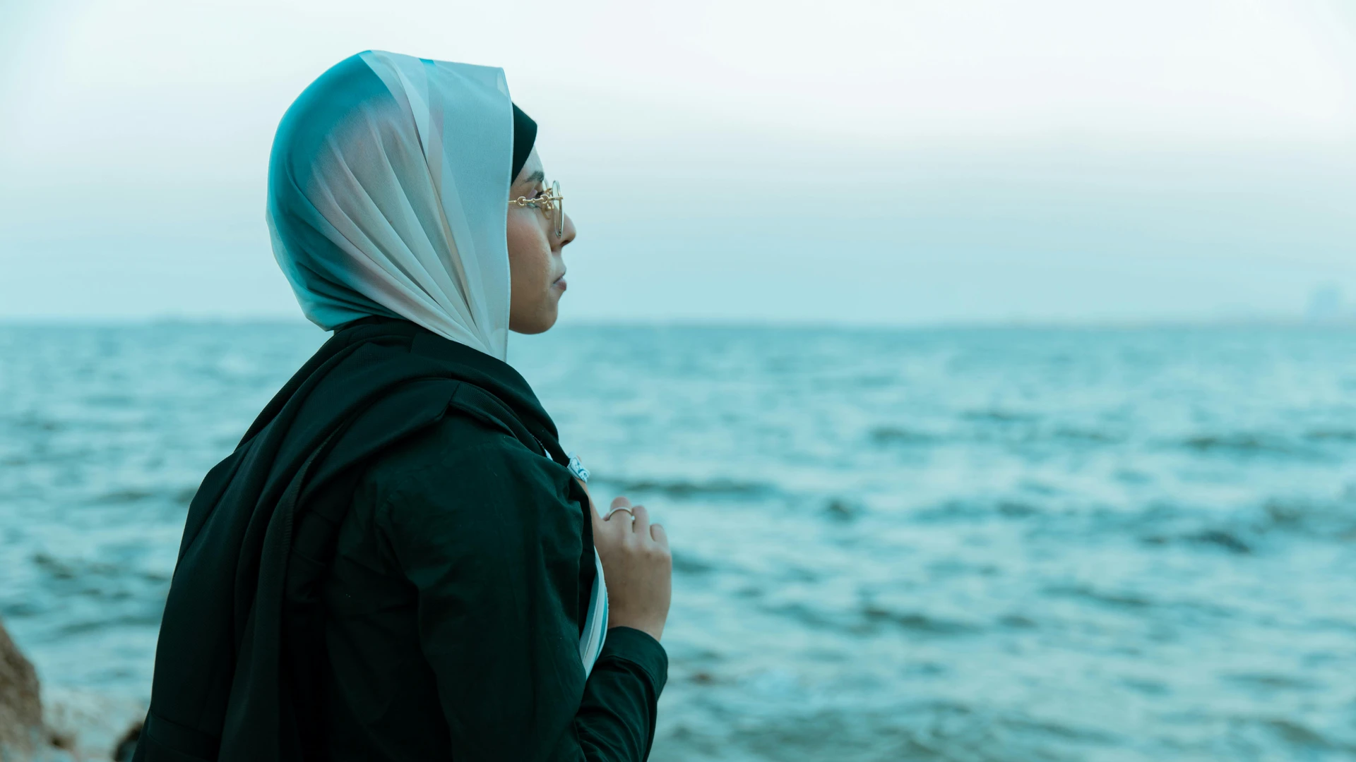 Alexandria, Egypt - Serene moment captured of a woman in hijab by the sea in alexandria, egypt.