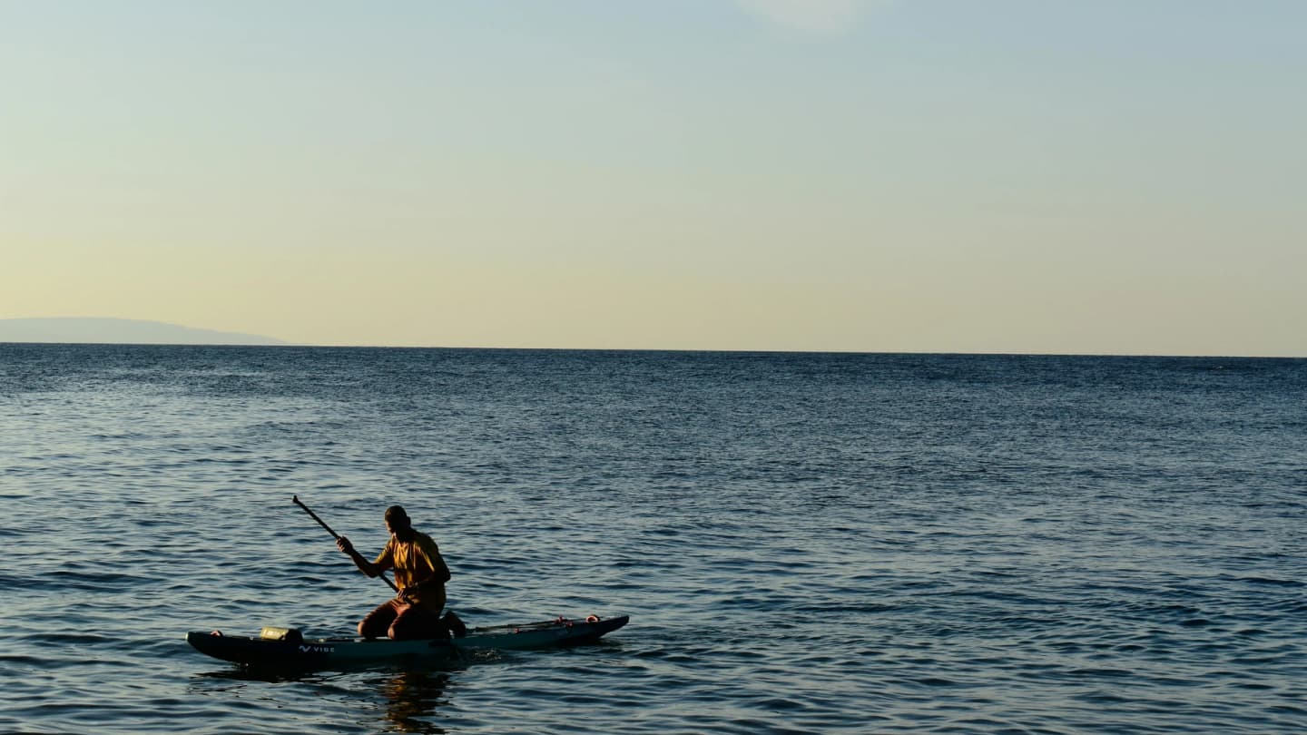 Dahab, Egypt - Person paddleboards on the calm sea during a picturesque sunset in dahab, egypt.