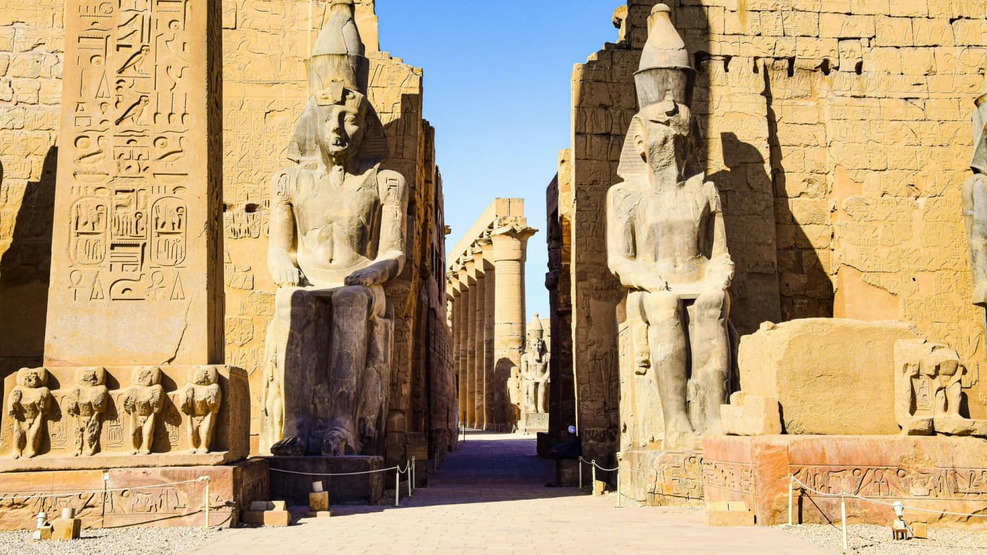 Dahab, Egypt - Entrance to luxor temple adorned with ancient egyptian statues under clear sky.
