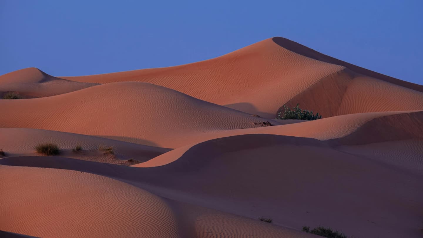Dahab, Egypt - Tranquil view of desert sand dunes under a twilight sky, showcasing natural beauty.