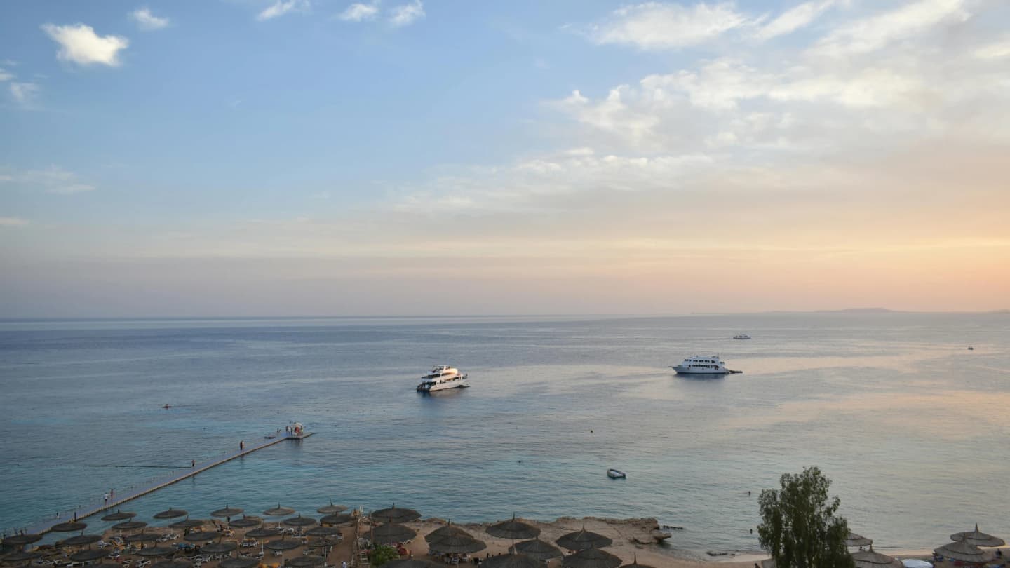El Gouna, Egypt - Stunning aerial view of sharm el sheikh's beach and sea during sunset with boats and parasols.