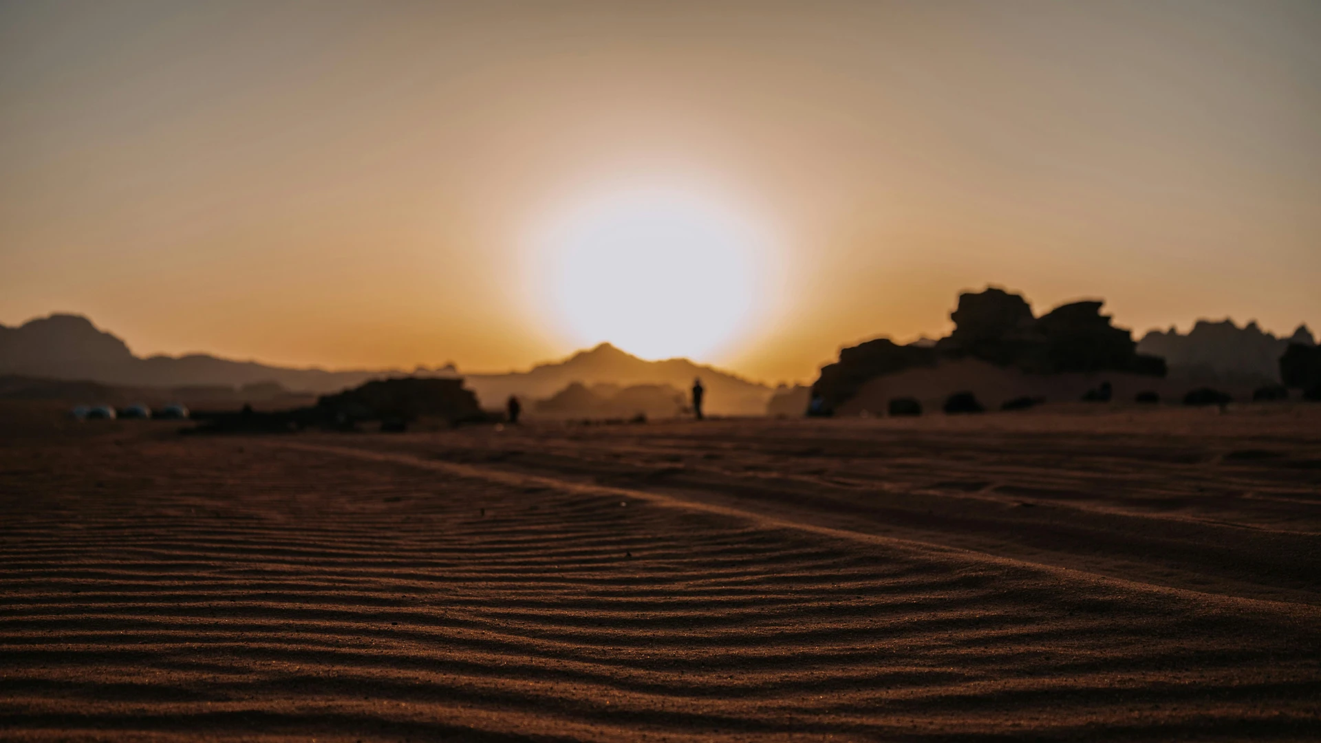 Hurghada, Egypt - Dramatic sunset casting warm glow over the vast barren wadi rum desert landscape.