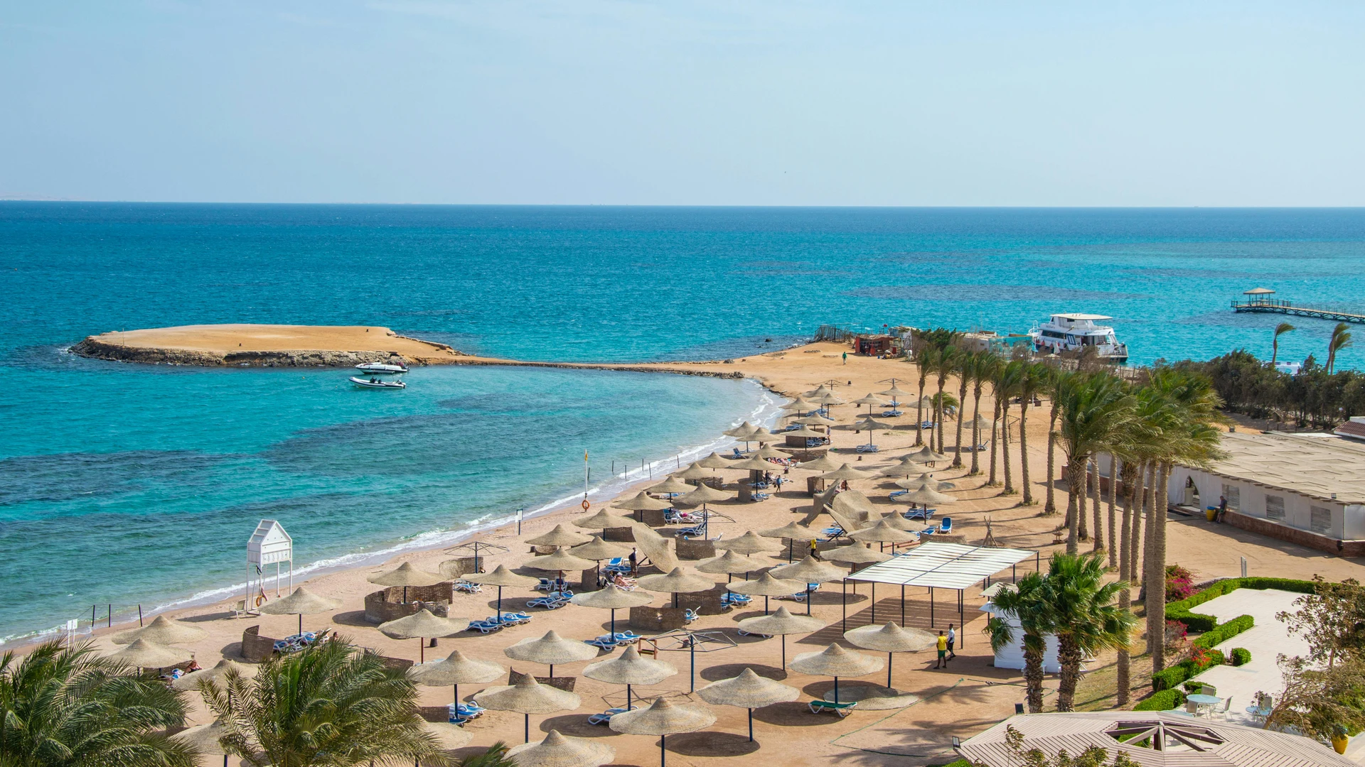 Hurghada, Egypt - Idyllic beach scene with rows of umbrellas and azure ocean, perfect for travel and relaxation themes.