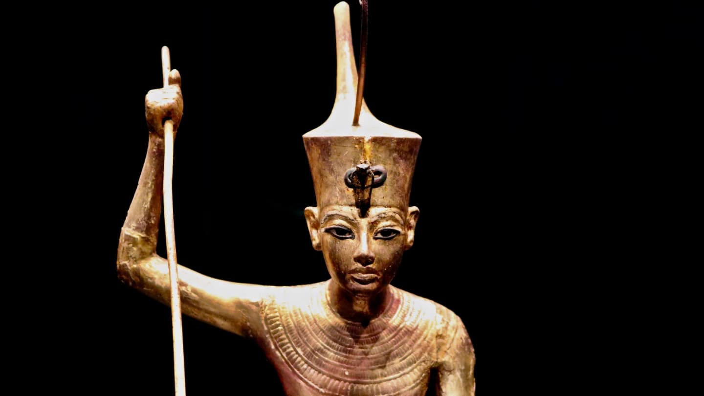 Makadi Bay, Egypt - Close-up of an ancient egyptian pharaoh gold statue on a black background.