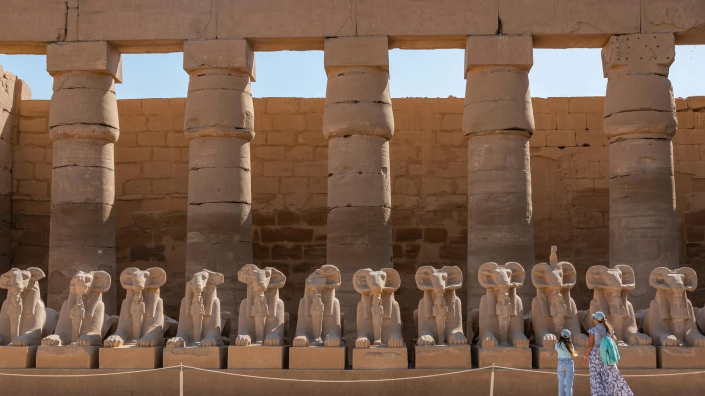 Marsa Alam, Egypt - View of the ram-headed sphinx statues at karnak temple complex with visitors exploring the site.