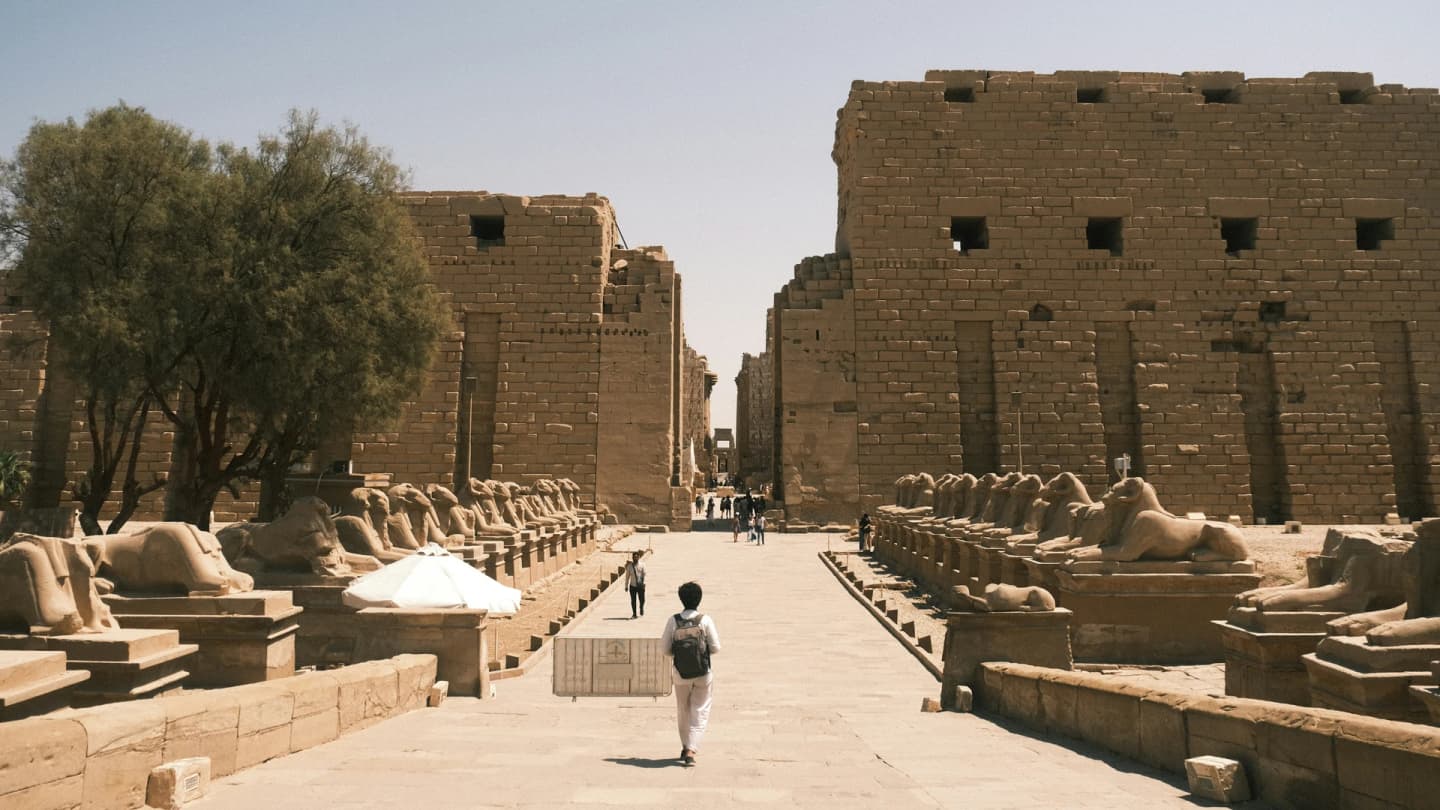 Safaga, Egypt - Person walks down an ancient avenue lined with sphinxes.