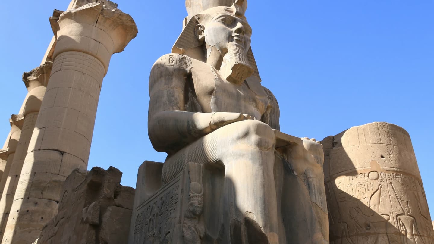 Safaga, Egypt - Statue of a man sitting in front of two tall pillars