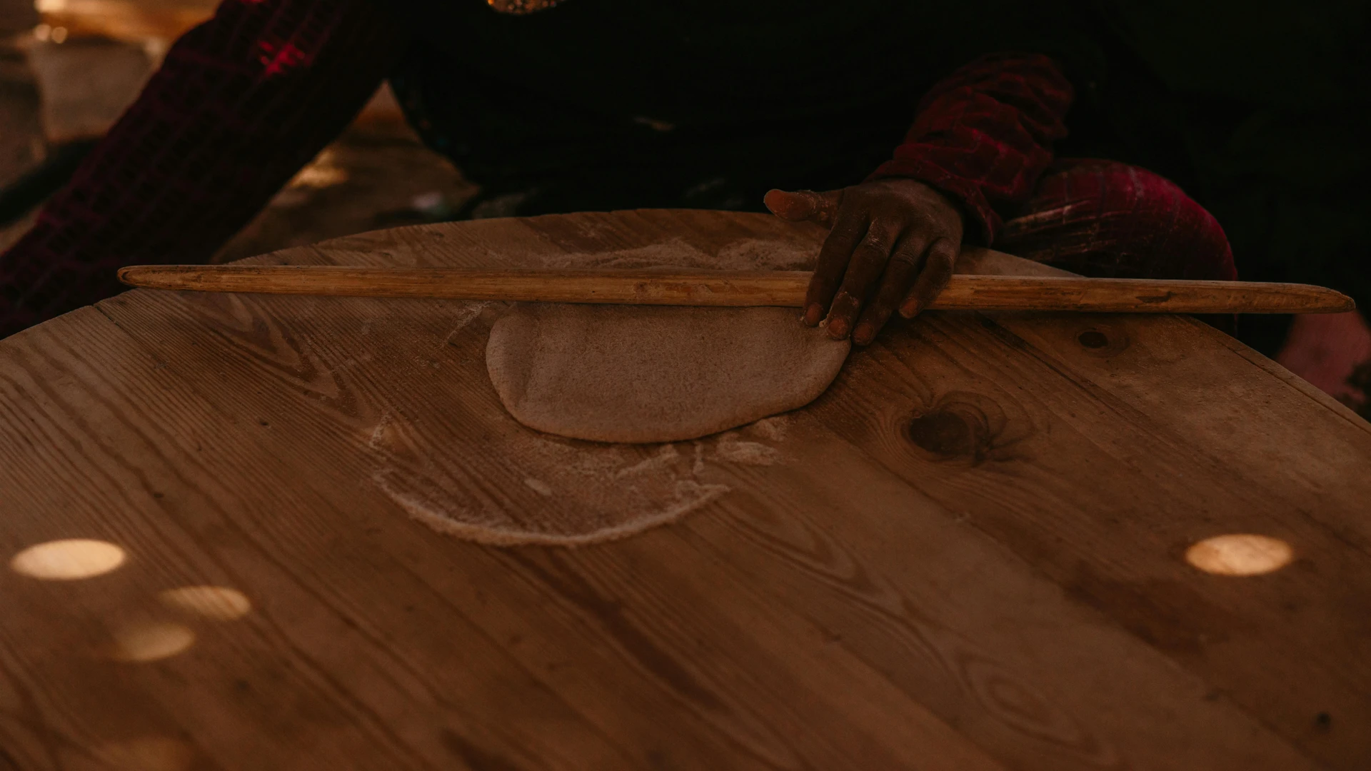 South Sinai, Egypt - Person rolls dough on a wooden table, capturing traditional bread-making in south sinai, egypt.