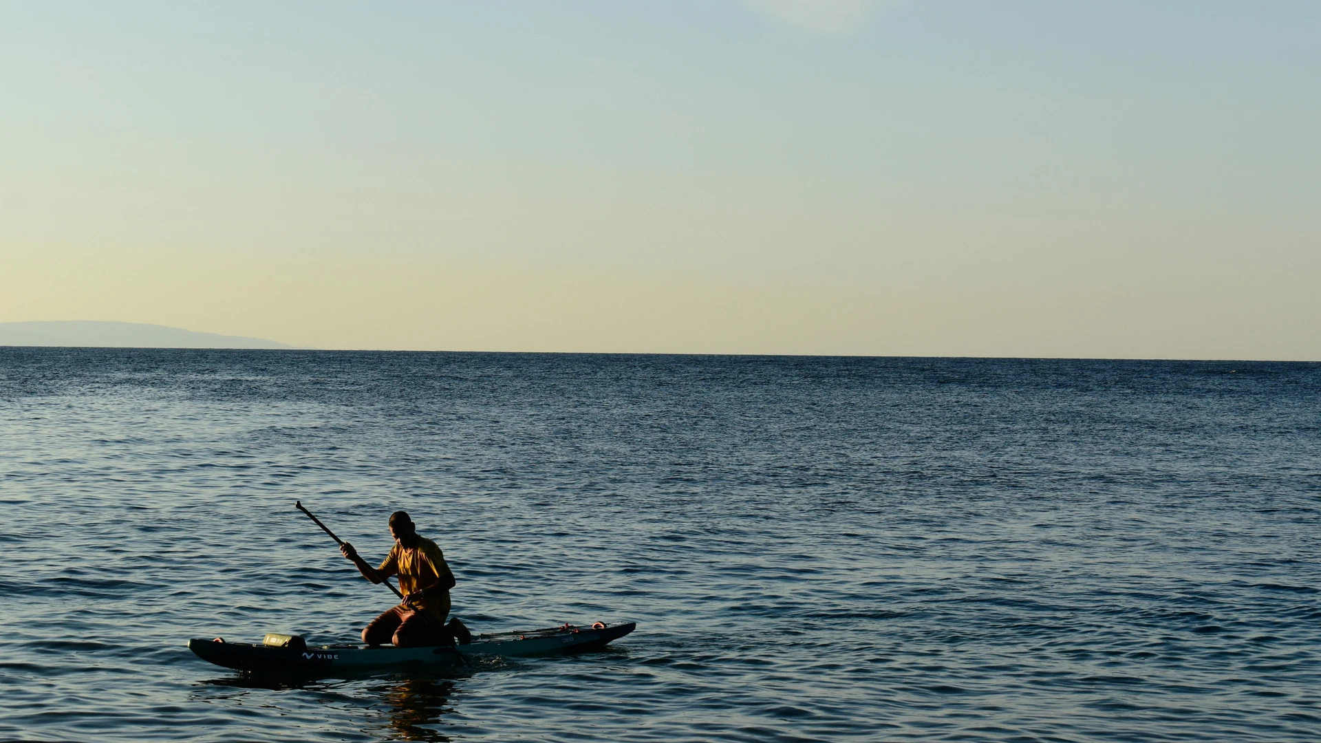 South Sinai, Egypt - Person paddleboards on the calm sea during a picturesque sunset in dahab, egypt.