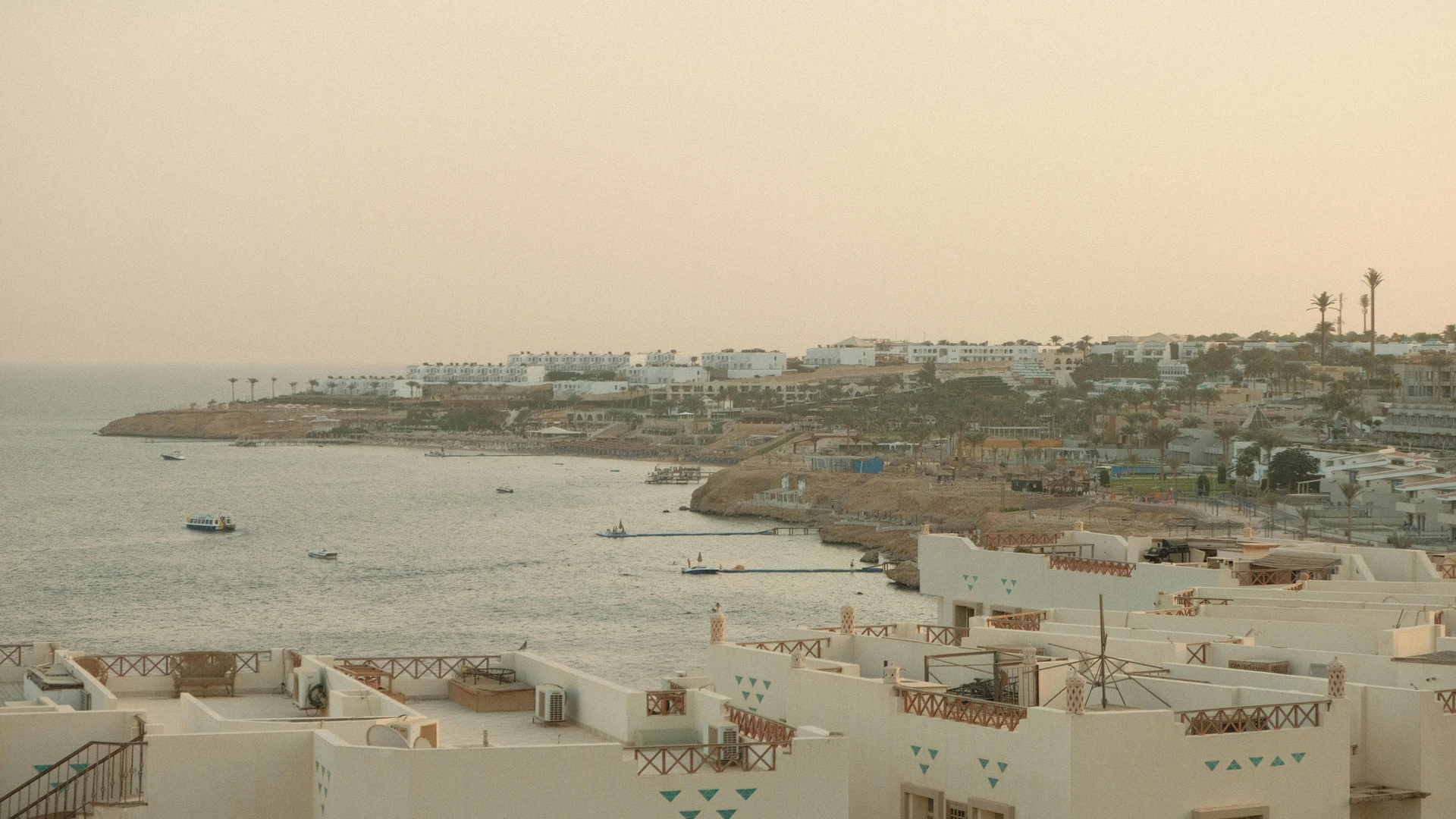 El Alamein, Egypt - Breathtaking view of sharm el sheikh coastline at sunset with calm sea and resort buildings.