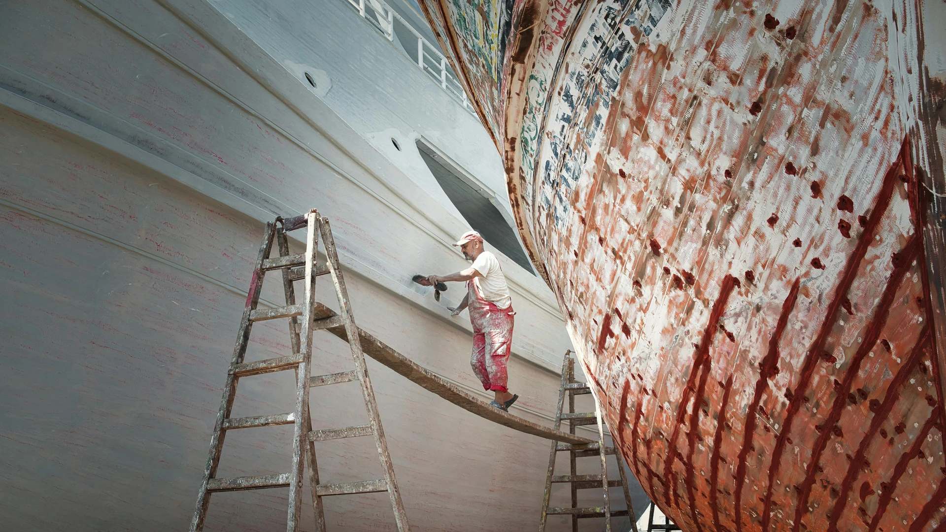 El Alamein, Egypt - Worker repairing boats in ras el-bar, egypt. a scene of maritime craftsmanship.